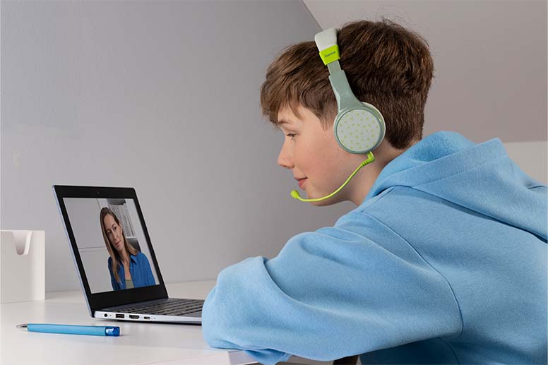 Kind mit "Bluetooth-Kinderkopfhörern" am Laptop.